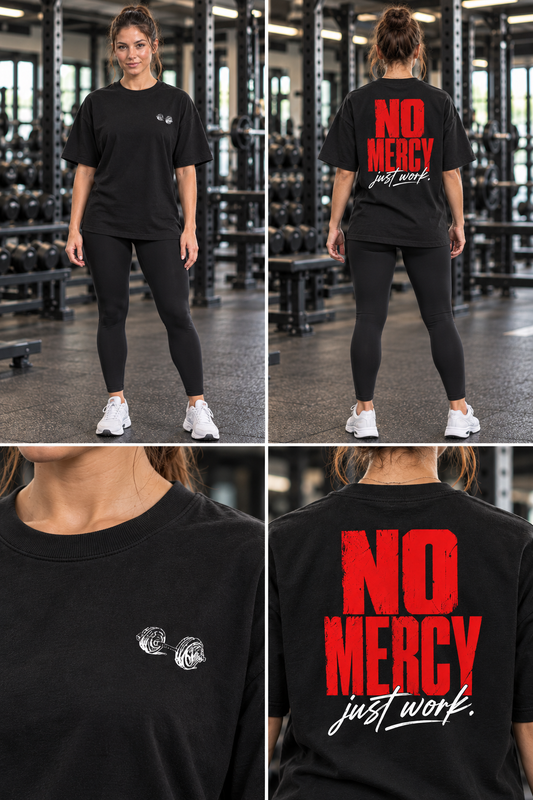 Female model wearing a black oversized gym T-shirt, showing the dumbbell front graphic and No Mercy Just Work back print.
