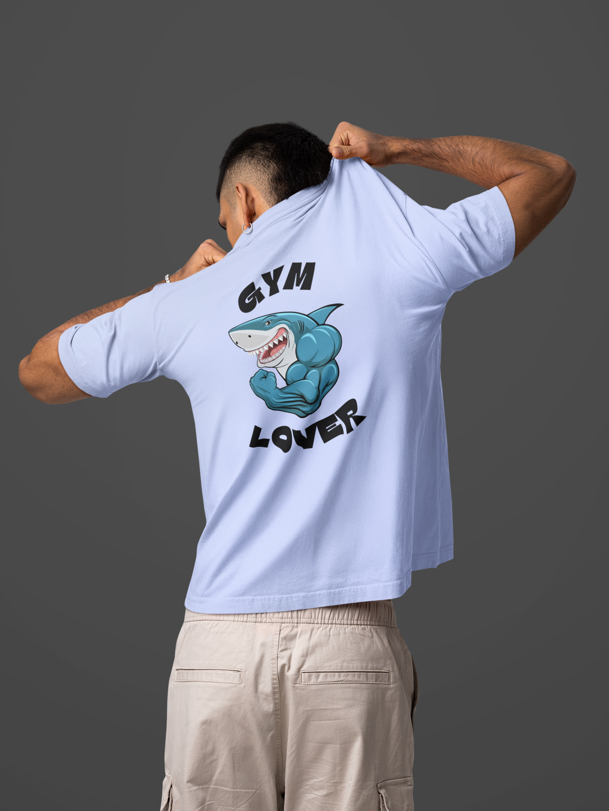 Back view of a man wearing a white oversized "Gym Lover" shark graphic t-shirt.