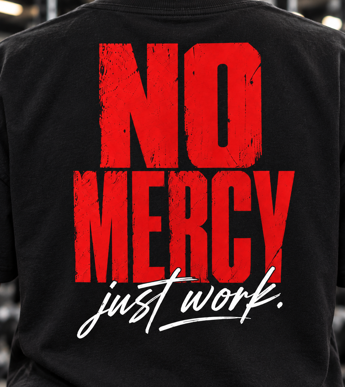 Close-up of the red No Mercy and white Just Work graphic printed on the back of a black T-shirt.