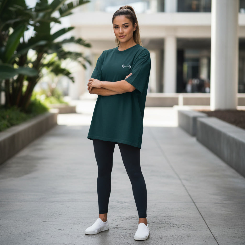 Woman wearing dark green Mind Set oversized gym T-shirt with dumbbell front graphic
